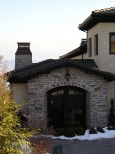 Large custom made chimney caps sit on top of a Tuscan style home