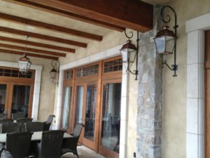 Large curled brackets supporting copper lanterns