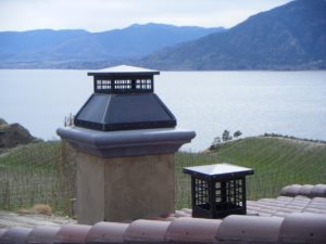 two chimney caps overlooking a winery and lake