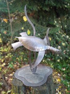 Forged, fabricated and inflated mild steel depicting a sea turtle swimming through the sea grass.