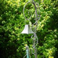 Six foot tall, outdoor metal art sculpture depicting a teenage girl walking her dog - under a decorative lantern stand